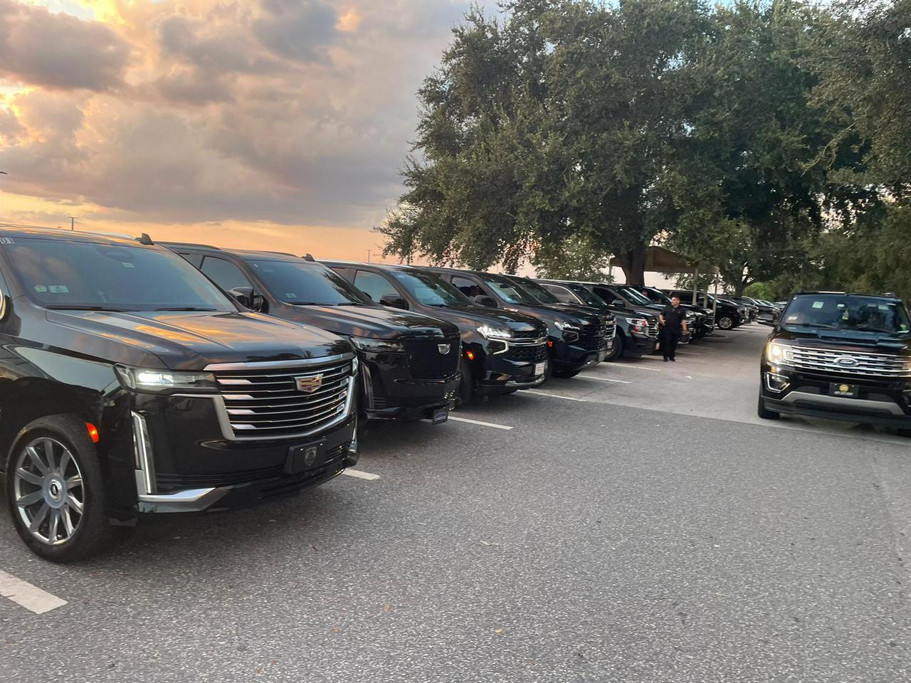 Row of black luxury SUVs lined up for corporate or group transport.