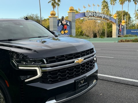 Front angle of luxury black SUV at resort area, professional transport.